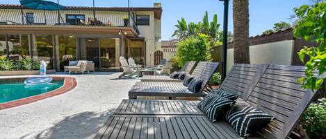 A poolside area with lounge chairs and a pool.