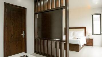A bedroom with a bed, bedside table, and a TV unit.