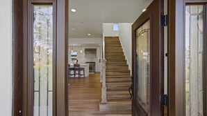 A staircase leading to a second floor, a kitchen area with modern appliances, and a dining space with a table and chairs. - Iaorana: Newly remodeled luxury 3 bedroom with Ocean Views (Carmel)