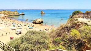 A beach with clear blue water, rocky formations, and people enjoying the sun. - Coastal Escape with Backyard Beach, Inema INES (Lagos)