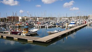 A marina with numerous boats docked along a wooden pier. - Coastal Escape with Backyard Beach, Inema INES (Lagos)