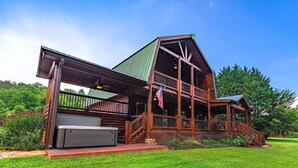 A two-story wooden cabin with a green roof, a covered porch, and a flag. - Take Me to the River – Blue Ridge, GA (Blue Ridge)