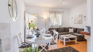 Una sala de estar con sofá, mesa de comedor, sillas y una mesa de centro.