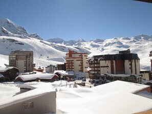 A snow-covered mountain town with buildings and a ski slope in the background. - 200m from ski slopes, 5th floor, balcony, tv, 41m², Val Thorens (Val Thorens)
