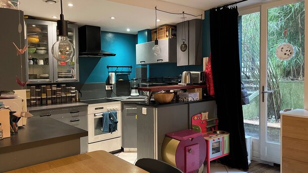 A modern kitchen with a built-in oven, a coffee machine, and a small children's play area. - Un Havre de Paix en Plein Paris (Paris)