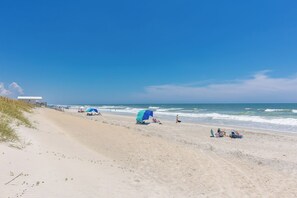 A beach with clear skies, a sandy shore, and a few beach umbrellas. - Aint Dat A Beach II - 2BR Upper Unit on the 2nd Row (North Topsail Beach)