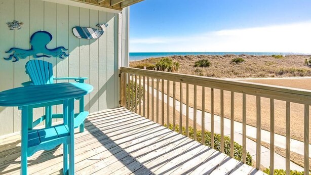 A wooden deck with a view of the beach. - 715 Surf - Gorgeous 1BR Surf Condo with Washer and Dryer (Surf City)