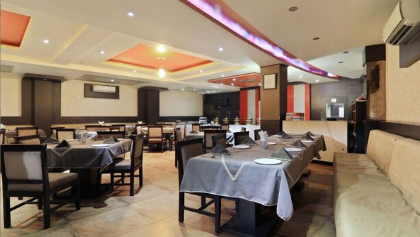 Un restaurante con varias mesas, sillas y un sofá.