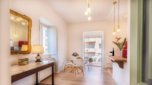 Ein Flur mit Holzboden, einem Tisch mit Stühlen, einem Spiegel und einer Lampe.