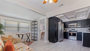 Eine moderne Küche mit einem schwarzen Kühlschrank, Edelstahlgeräten und einer gefliesten Spritzschutzwand.