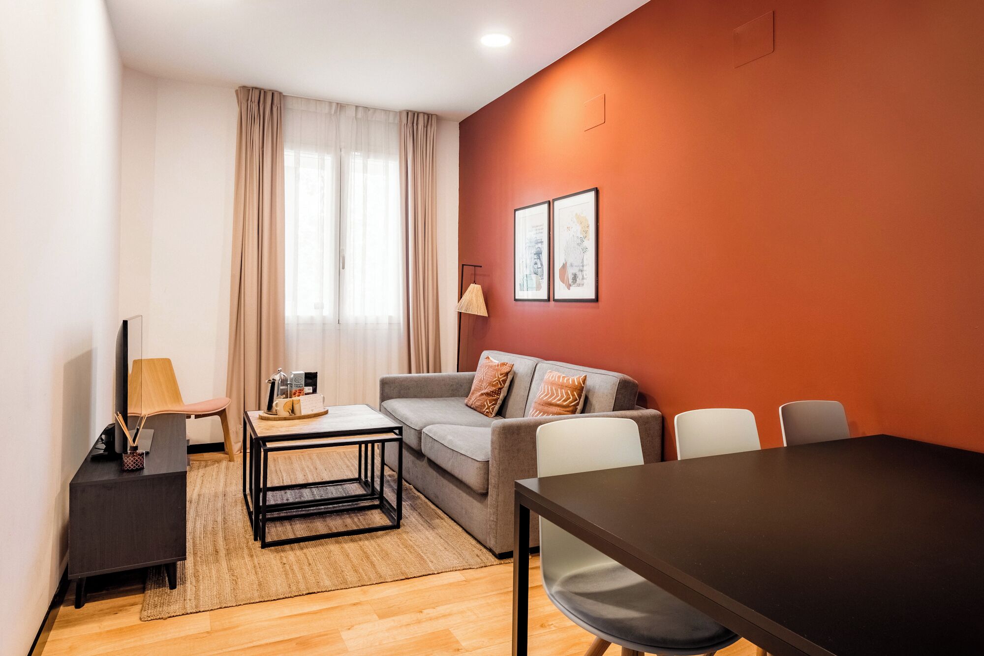 Un salon moderne comprenant un canapé, une table basse, un téléviseur et une table à manger.