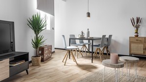 A modern living room with a TV, dining table, chairs, and a plant. - Bob W Madrid Atocha (Madrid)