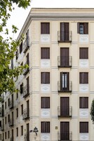 Ein mehrgeschossiges Gebäude mit einheitlichen Fensterläden und Balkonen.