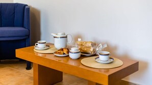 A dining table with a coffee set, a teapot, a loaf of bread, and a plate of pastries. - Kitries Summer Getaway - Eden Cozy Suite (Kitries)