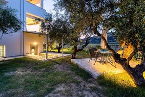 A modern house with a patio area, outdoor seating, and a view of the surrounding landscape.