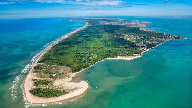 An aerial view of a coastal area with a beach, forested land, and a small island. - Beautiful new house close to beaches and shops (Saint-Georges-d'Oléron)