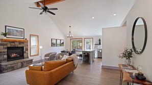 Ein geräumiges Wohnzimmer mit Kamin, Essbereich und Küche.