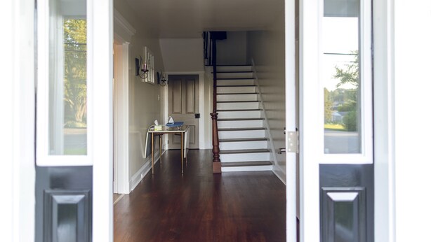 Ein Flur mit einer Holztreppe, die zu einer oberen Etage führt.