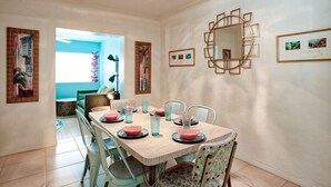 A dining area with a wooden table set for four, surrounded by chairs. - Fun Getaway in the Sun Private Saltwater Pool Yard (Gulfport)