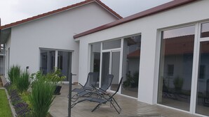 A modern house with a patio, outdoor seating, and a garden. - Vacation apartments Hesselperle (Gerolfingen)