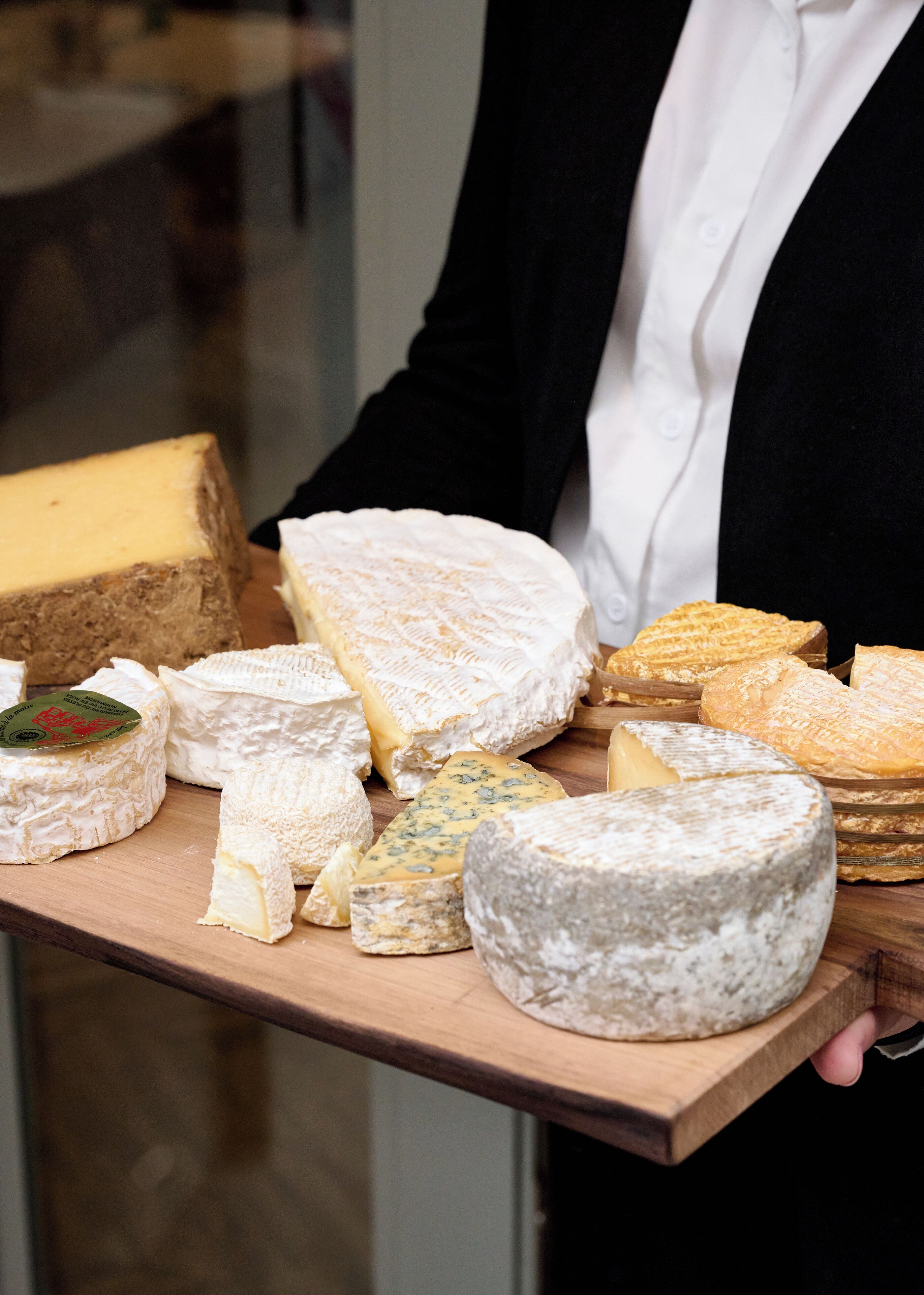 A variety of cheeses on a wooden board.