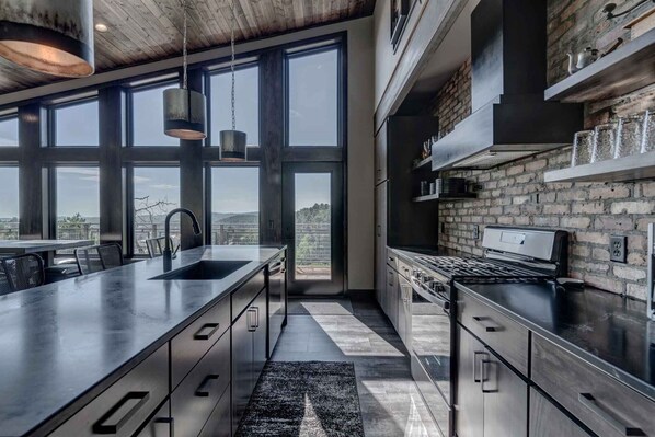 Modern kitchen with a large island, range hood, and oven, offering a functional space with clean lines and ample storage.