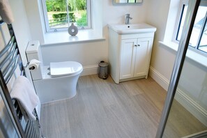 A bathroom with a toilet, sink, and window. - The Stables -  Retreat Group (Pitlochry)
