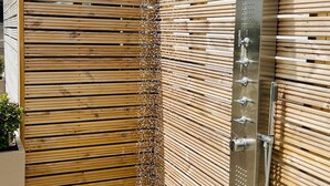 Una cerca de madera con una fuente vertical y una reja de metal.