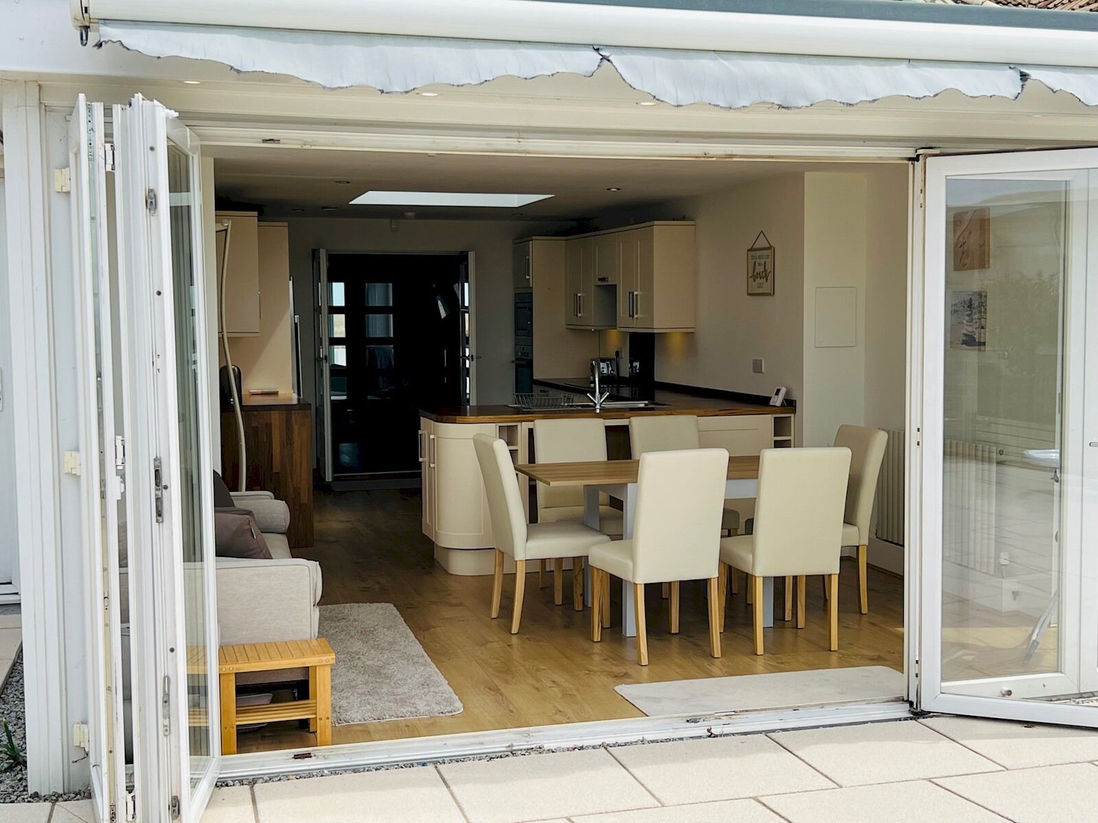 Un espace de vie compact et ouvert, comprenant une cuisine, un coin repas et un petit coin salon.