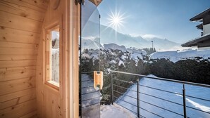 Una cabana de fusta amb un balcó que domina un paisatge de muntanya nevada.