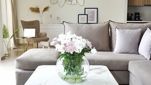 A modern living room with a marble coffee table, a beige sofa, and a glass vase with flowers. - Luxurious, modern, cozy apartment in Heraklion (Heraklion)