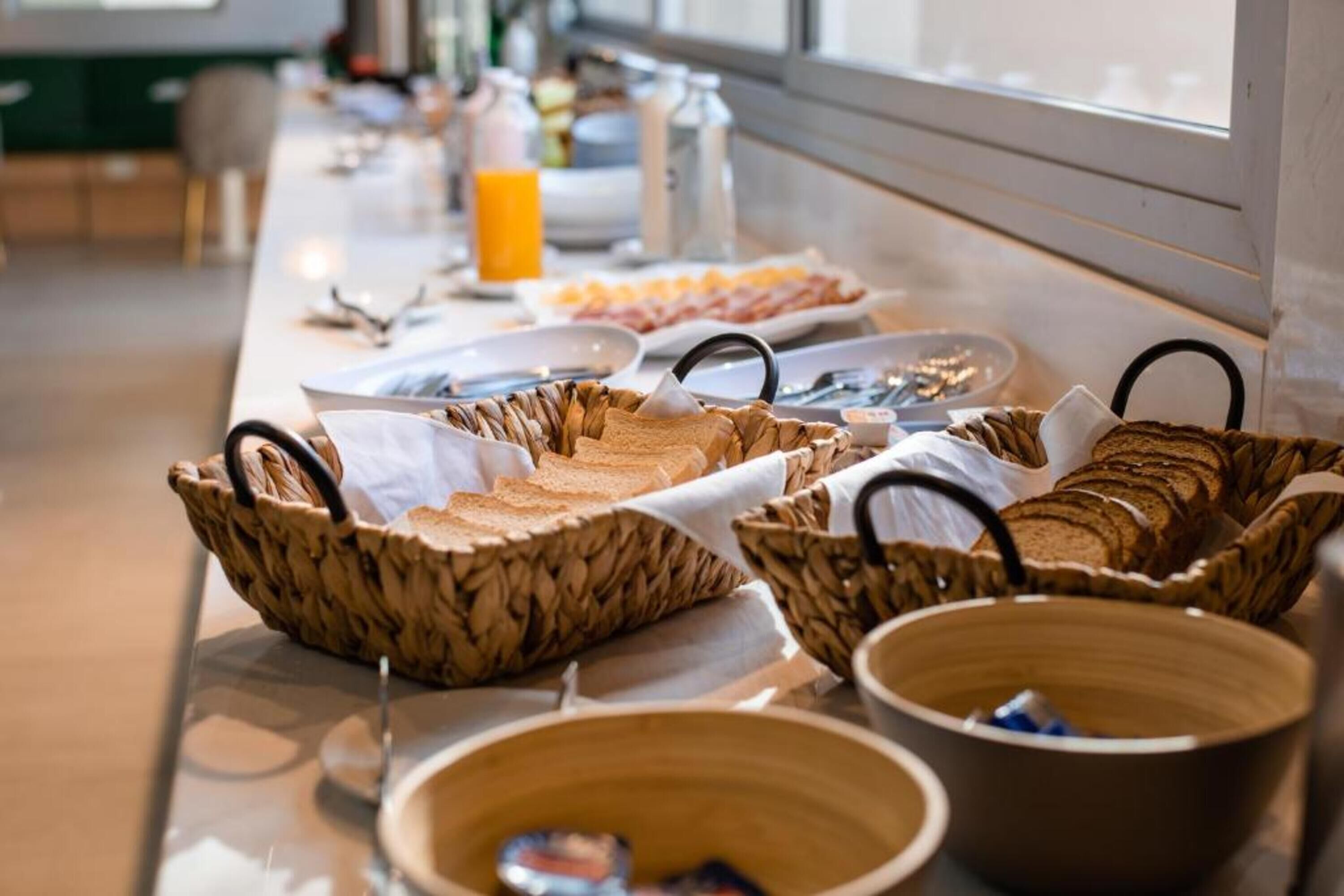 A breakfast buffet with various food items and baskets.