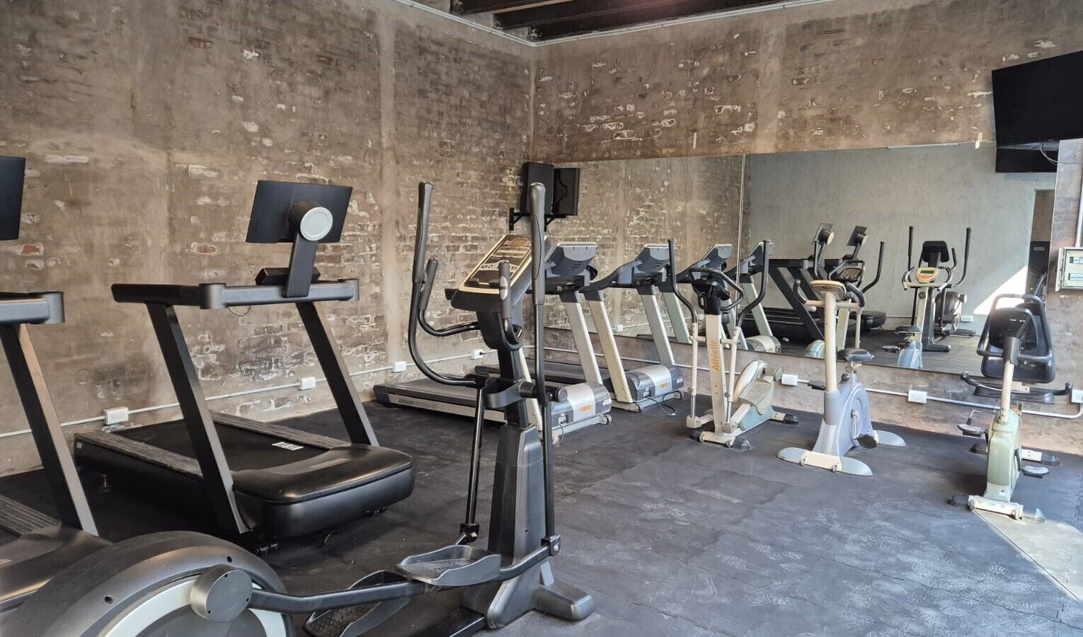 A gym with treadmills, elliptical machines, and stationary bikes.