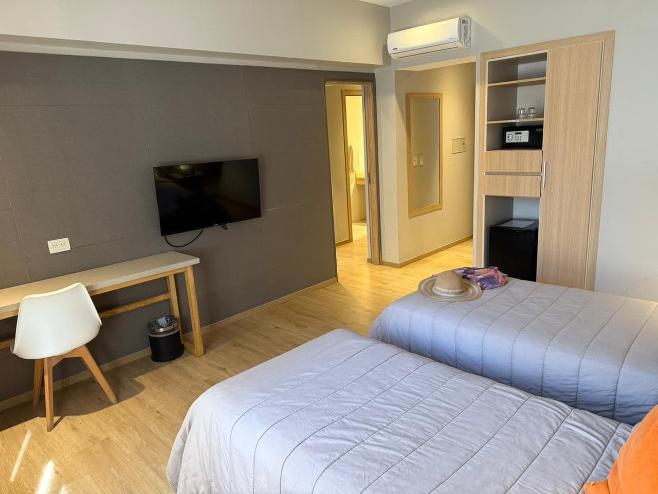 A hotel room with a bed, a desk, a television, and a wardrobe.