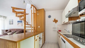 A modern kitchen with a wooden island, built-in oven, and white cabinetry. - La Dunette - Two Bedroom Apartment, Sleeps 4 (La Grande-Motte)