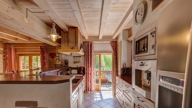 Una cucina con mobili in legno, un'isola centrale e un'ampia finestra.