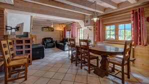 Un interno in legno con tavolo da pranzo, sedie, divano e camino.