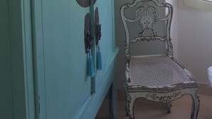 A room with a teal cabinet, a framed portrait on the wall, and a window with a view of greenery. - Blue Dream Cannes Guesthouse (Cannes)