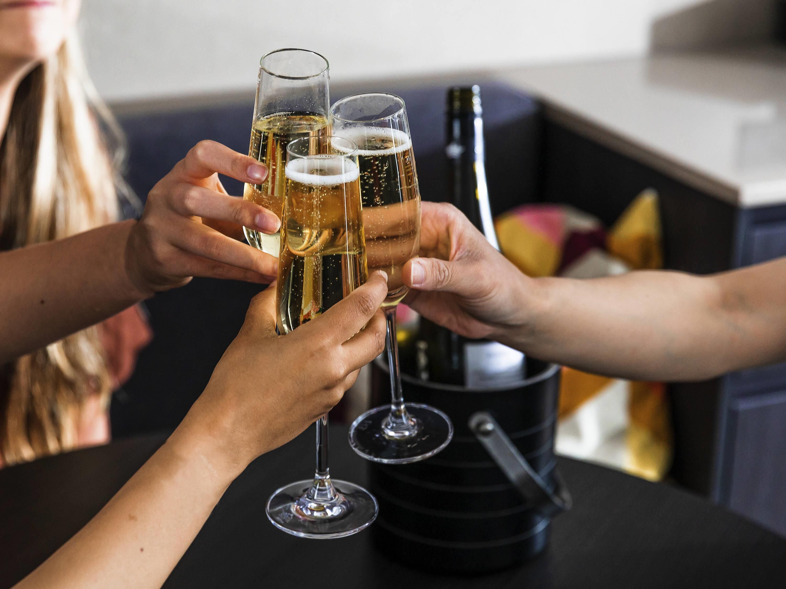 A group of people toasting with champagne glasses at a table.