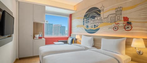 A hotel room with two beds, a TV, a window with a city view, and a mural on the wall.