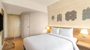 Quarto de hotel com uma cama grande, um guarda-roupa, uma televisão e decoração de parede.