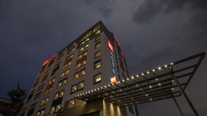 Un hotel de varios pisos con señalización iluminada y una galería techada.