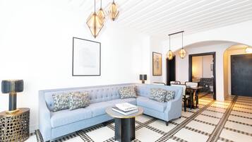 Una sala de estar moderna con un sofá azul claro, una mesa de centro redonda y un suelo con un estampado geométrico.