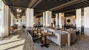 A spacious restaurant with high ceilings, modern chandeliers, and a patterned floor. - Fairmont Hotel La Marina Rabat Sale (Salé)