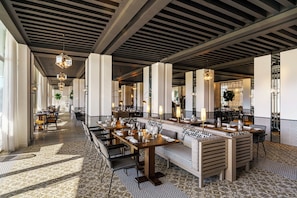 A spacious restaurant with high ceilings, modern chandeliers, and a patterned floor. - Fairmont Hotel La Marina Rabat Sale (Salé)