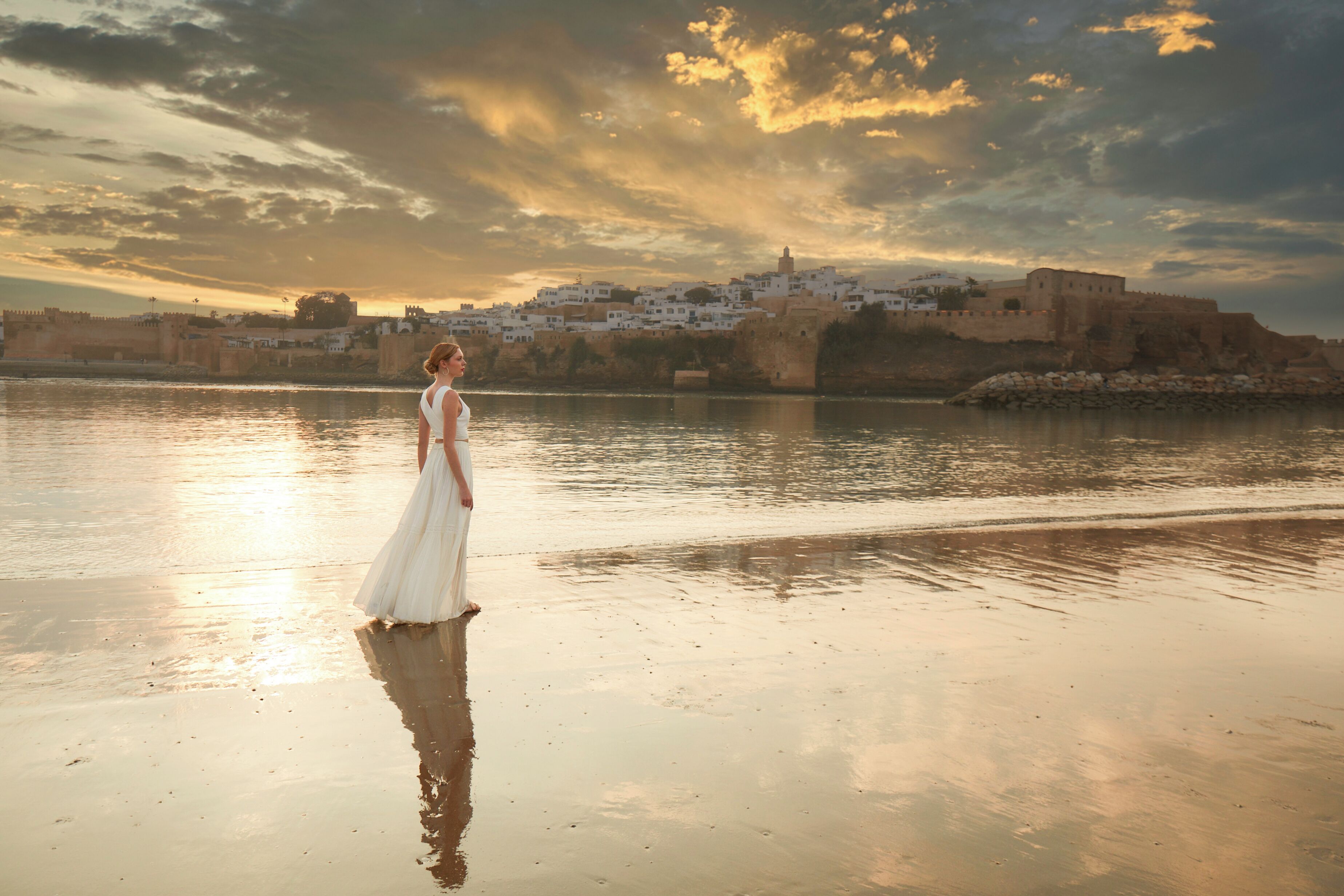 Una playa con un castillo al fondo.