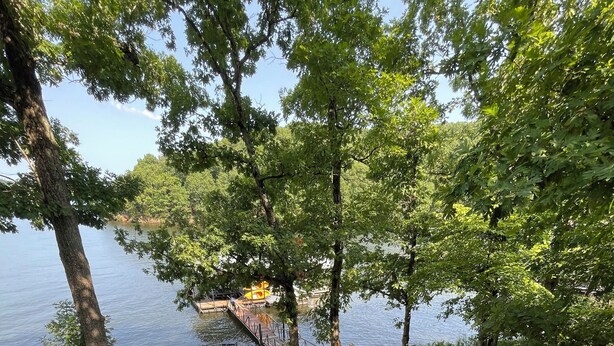Une terrasse en bois avec des sièges extérieurs, donnant sur un lac.
