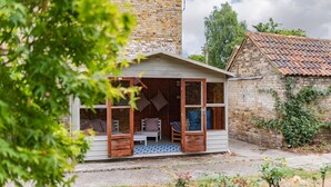 A cozy wooden cabin with a porch, large windows, and a brick wall. - Large family home in Sandwich - Poplar House (Sandwich)