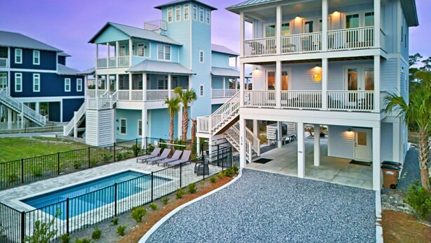 A multi-story residential building with a pool, outdoor seating, and a staircase leading to the upper floors. - Gulfview new construction w/private, heated pool and beach gear! (Port St Joe)