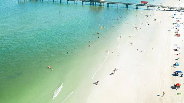 An aerial view of a beach with a pier extending into the water, featuring several red-roofed structures. - Heated Pool~Pickleball~Hot Tub~Game Room~Basketball~Fire Pit~Bunk Room~4 Kings (Tampa)